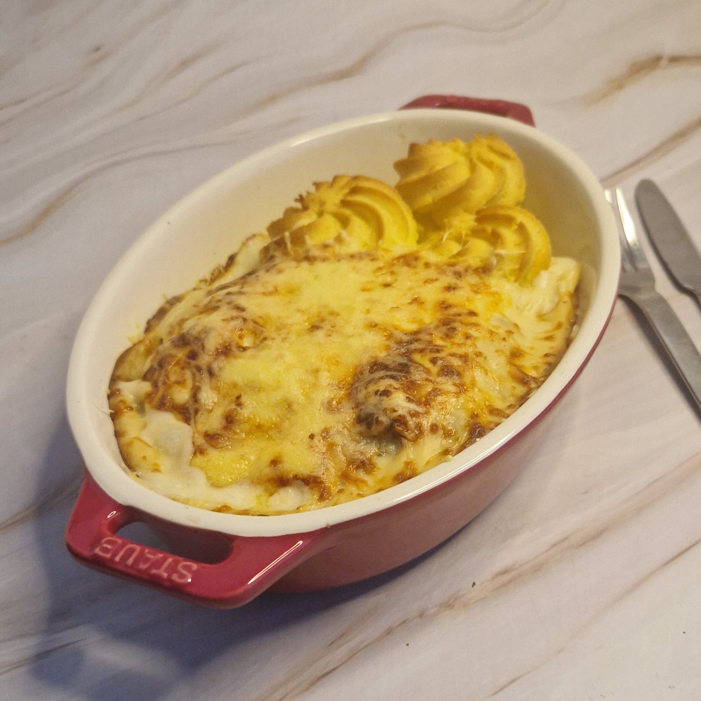 Gegratineerd witloof met gerookte zalm, duchesseaardappel & Nantuasaus